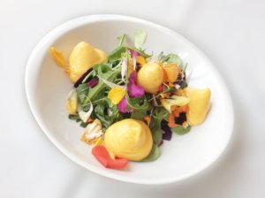 Salátek z macešek, aksamitníku, polníčku a rukoly doplněné o rakytníkovou espumu